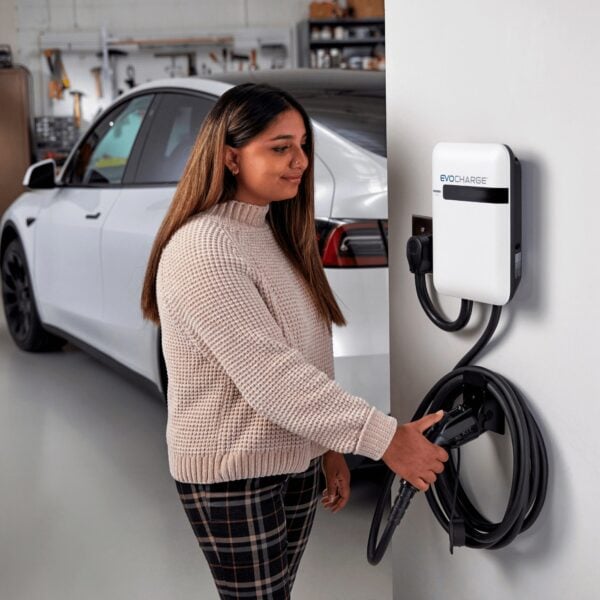 Woman using the EvoCharge EV charger in her garage.