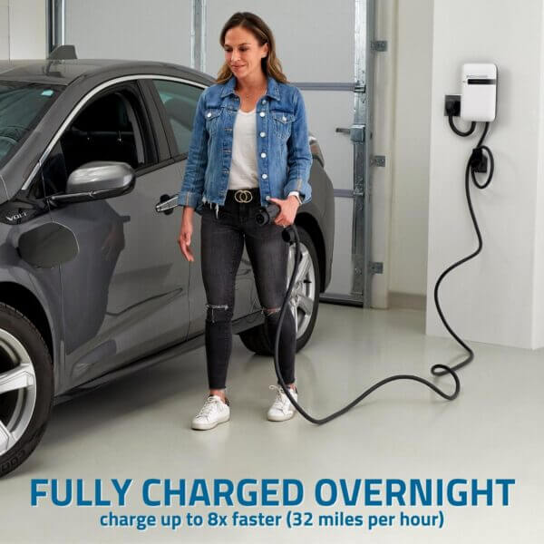 A woman in her garage unplugs her EV charger after having her electric car charge overnight.