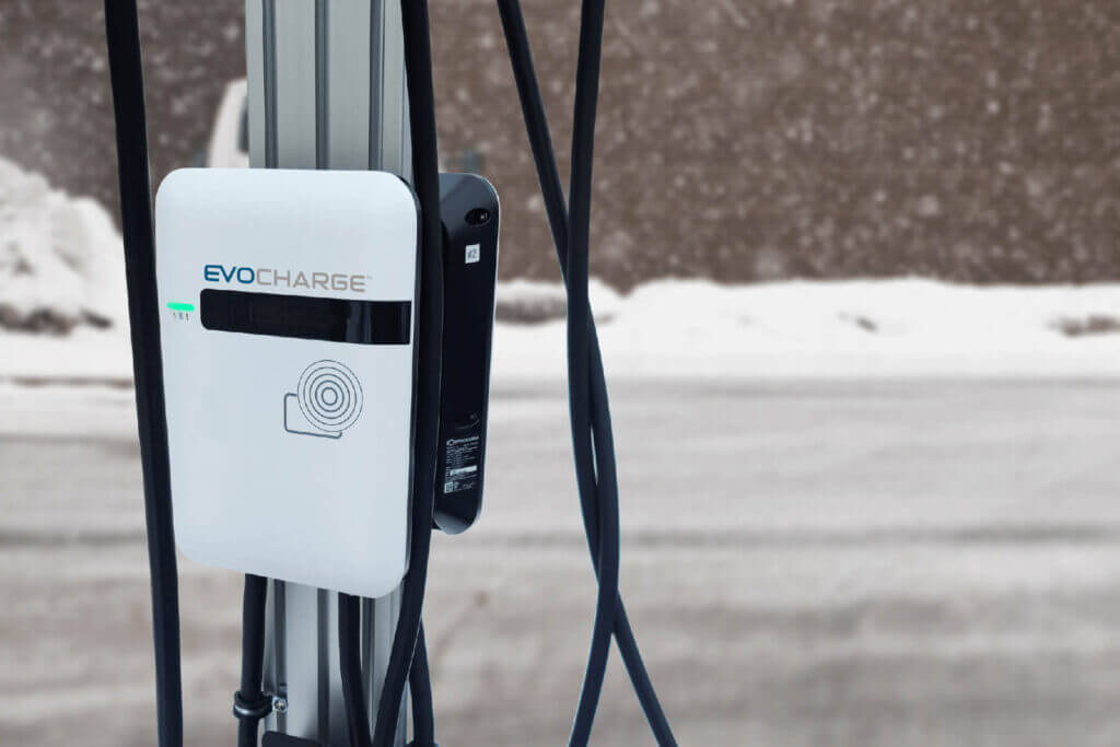 A zoomed in picture of an EvoCharge charger with a snowy background