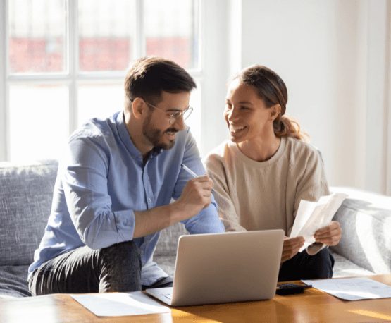 Couple on a couch discussing finances.