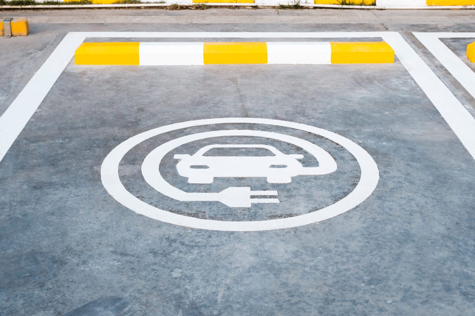 A parking space with a logo that marks it as a place for electric cars to park.