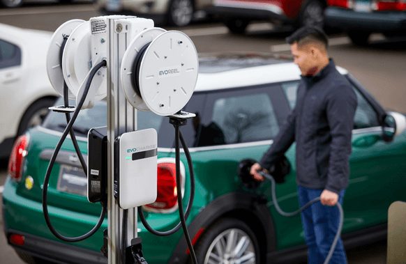 A man charging his vehicle using the EvoReel.