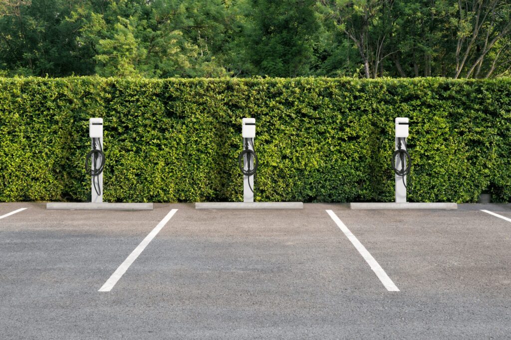 Three EvoCharge units mounted to pedestals in a parking lot